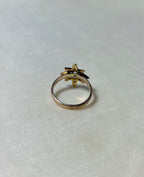 back view of gold star ring on white fabric background 