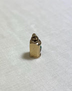 Gold charm on a white fabric background