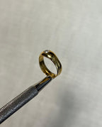 side view of gold ring with diamond on white background 