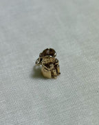 small gold toby jug charm on cream fabric background 