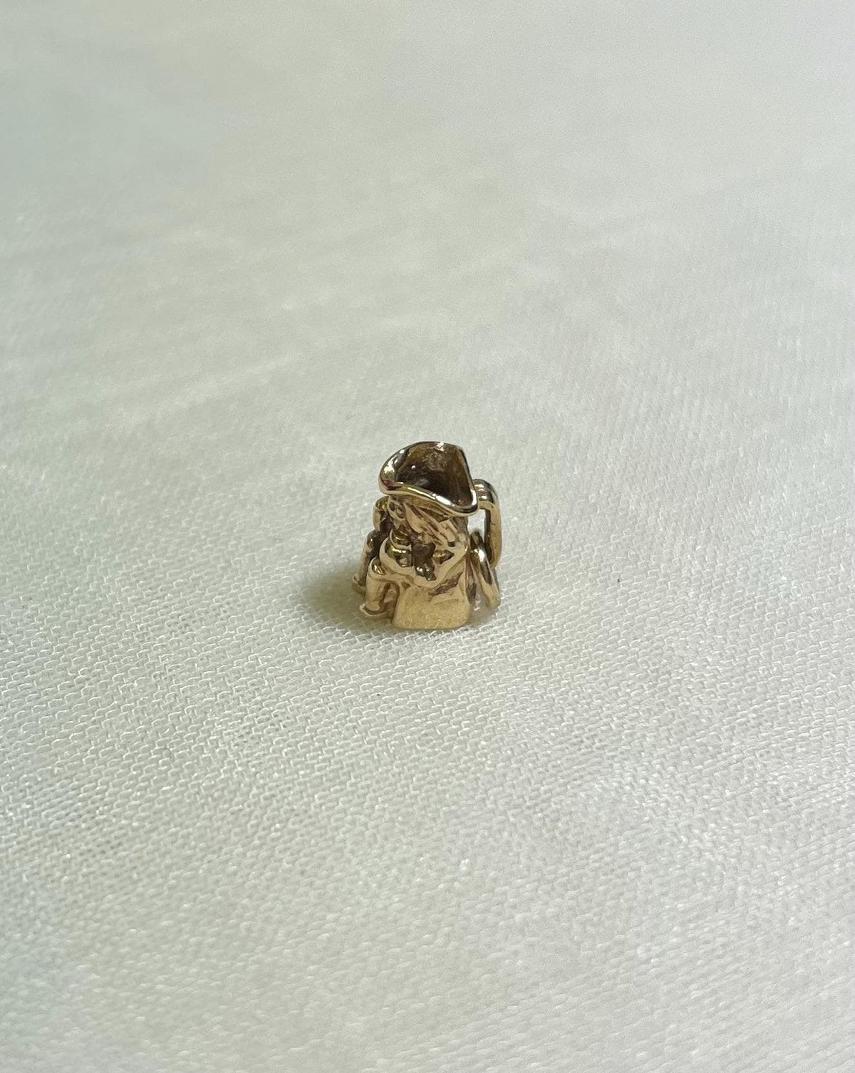 small gold toby jug charm on cream background